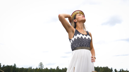 Portrait of a beautiful fashionable woman in a field of wheat harvest.