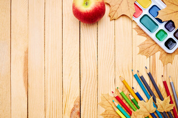 Wall Mural - back to school concept. education and study stationery on a wooden desk. above view. decorated with yellow maple leaves