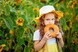 © Any Grant - a little girl looks through a bagel in a field of sunflowers in summer