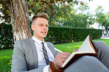 businessman in the park works with a diary