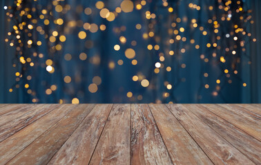 Wall Mural - holiday illumination and decoration concept - empty wooden surface or table with christmas golden lights on blue background