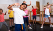 © JackF - Portrait of smiling african boy showing dance elements during group class in dance center