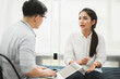 © Nopphon - Young handsome asian psychologist doctor using laptop consulting to female patients in therapy session.
