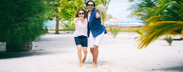 Beautiful young couple joyfully have fun on a tropical beach, Happy summer sea vacation lifestyle design.