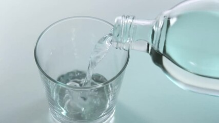 Poster - pouring mineral water into glass from bottle