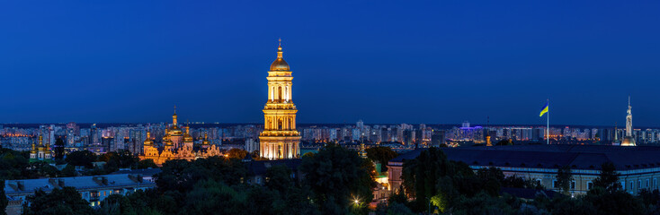 Wall Mural - View to the Bell Tower of Kyiv Pechersk Lavra  and cityscape behind of it at sunset.