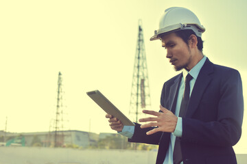 Asian Engineer using tablet working on site construction