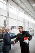 © JustLife - Colleagues working together. Arhitect and worker handshake in factory.