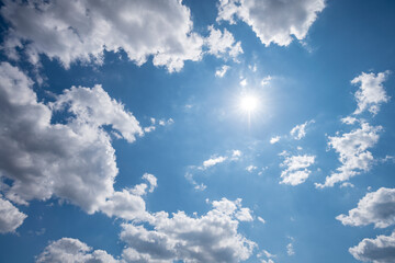 blue sky photographed with clouds and sun upwards