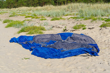 Wall Mural - disassembled blue tent on sandy beach at seacoast. adventure travel concept with copy space. Tent in sunny day at baltic sea beach in Aegna Island,