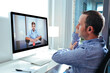 © GENETTICA - Young business man videoconferencing with doctor on computer at home