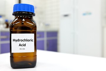 Sticker - Selective focus of strong hydrochloric acid chemical in brown amber glass bottle inside a laboratory with copy space.