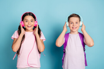 Wall Mural - Photo excited two small kids classmates boy girl have lesson break pause listen headset modern music songs amazed volume sound wear casual pink purple t-shirt isolated blue color background