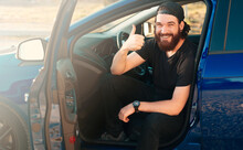 Photo Of Cheerful Bearded Man Sitting In His New Car And Showing Thumbs Up