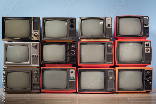 Fotografía Old vintage televisions pile in the room. TVs wall, background