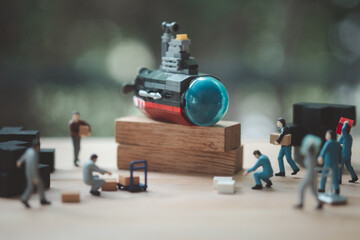 Wall Mural - Miniature worker people with toy submarine