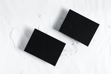 Two black cards mockup on powdered background with shadows.