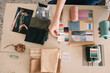 © Alberto Bogo/Stocksy - Hands Of Young Woman Choosing Fabric For Moodboard