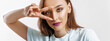 © Daria Lukoiko - Hey smile you. Portrait of cute glamor girl brunette woman with fashion make-up purple lips winking happily showing peace victory gesture as fooling around, being optimistic. Beautiful female face.