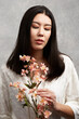 © Nicklaus Walter/Stocksy - Mixed Race Asian Woman Posing With Flowers