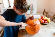 Boy Carving A Big Pumpkin