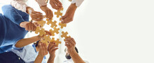 Happy Company Employees Joining Parts Of Jigsaw Puzzle During Work Meeting Or Team Building Activity