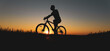 Silhouette of a man mountain biker at sunset riding bicycle