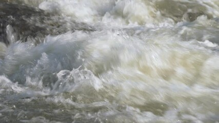 Wall Mural - Closeup detail, water flowing in river on sunny day forming white waves