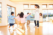 Leinwandbild Motiv 輪になって踊る幼稚園教諭と幼稚園児