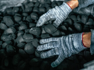 Coal mining - Man's hands in gloves holding natural black coal for back. Picture idea about coal mining, coal processing, energy source, environmental protection. Industrial coals. 