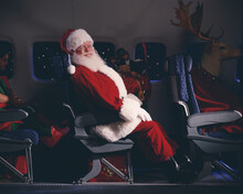 Santa Claus, Elves, Reindeer And Presents On An Airplane