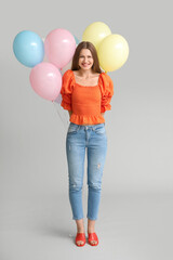 Sticker - Young woman with balloons on grey background