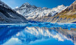 Hooker glacier melting with snow capped Mount Cook in the distance reflecting in the lake and a beautiful clear blue sky