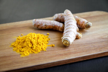 Turmeric root and spice powder on a cutting board