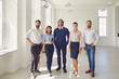 © Studio Romantic - Portrait of business coaches with office workers looking at camera in business center office.