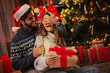 © Tijana - Man giving a Christmas present to his girlfriend