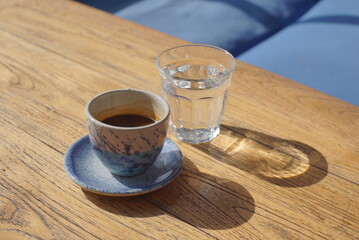 Espresso on a small cup with a glass of water