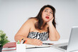 © THESHOTS.CO - Upset bored asian chubby woman at working desk in office.