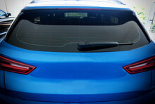Image Of Rear View Of Blue Car With Rear Wiper, Defogger Wires And Rear Lights On Background  