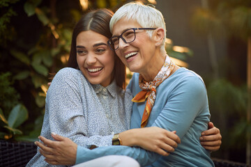 elderly mother and young adult daughter hugging each other