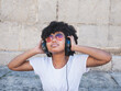© Novodiastock - Young black woman wearing headphones