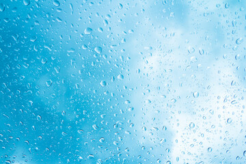 Blue water drops on glass or rain drop background 