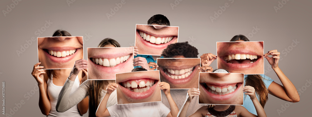 group of happy people holding a picture of a mouth smiling on a gray background - obrazy, fototapety, plakaty 