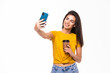 © F8  \ Suport Ukraine - Young beautiful woman using smartphone selfie time. Girl holding coffee cup and mobile phone isolated on white background.