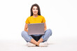 © F8  \ Suport Ukraine - Young woman sitting on the floor and using laptop on white background