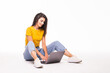 © F8  \ Suport Ukraine - Young woman sitting on the floor and using laptop on white background