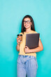 © F8  \ Suport Ukraine - Young woman with coffee cup and holding folder isolated on turquoise background.