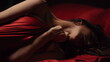Nude woman lying in bed under silk sheet. Sexy girl having intimate moments.