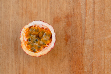 Maracuja cut in half and whole with leaf on wooden background. Passion fruit with fruit yellow juice and seeds.