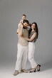 © Саша Тихова - Portrait of young happy man and woman holding newborn cute babe dressed in white unisex clothing. Caucasian smiling father and mother embracing tenderly adorable new born child. Happy family concept